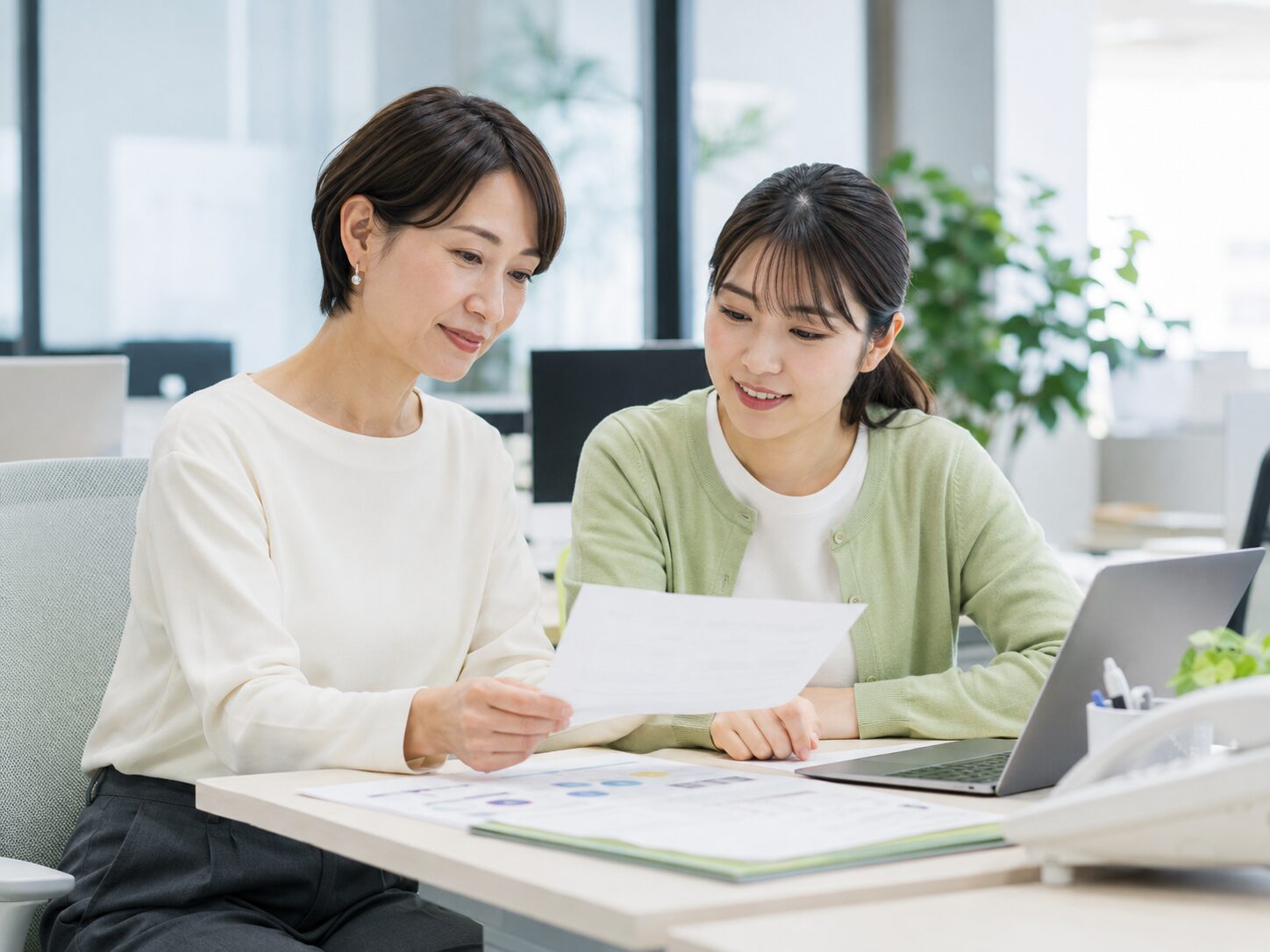職場で引き継ぎ内容を共有しながら頼む内容を整理する場面
