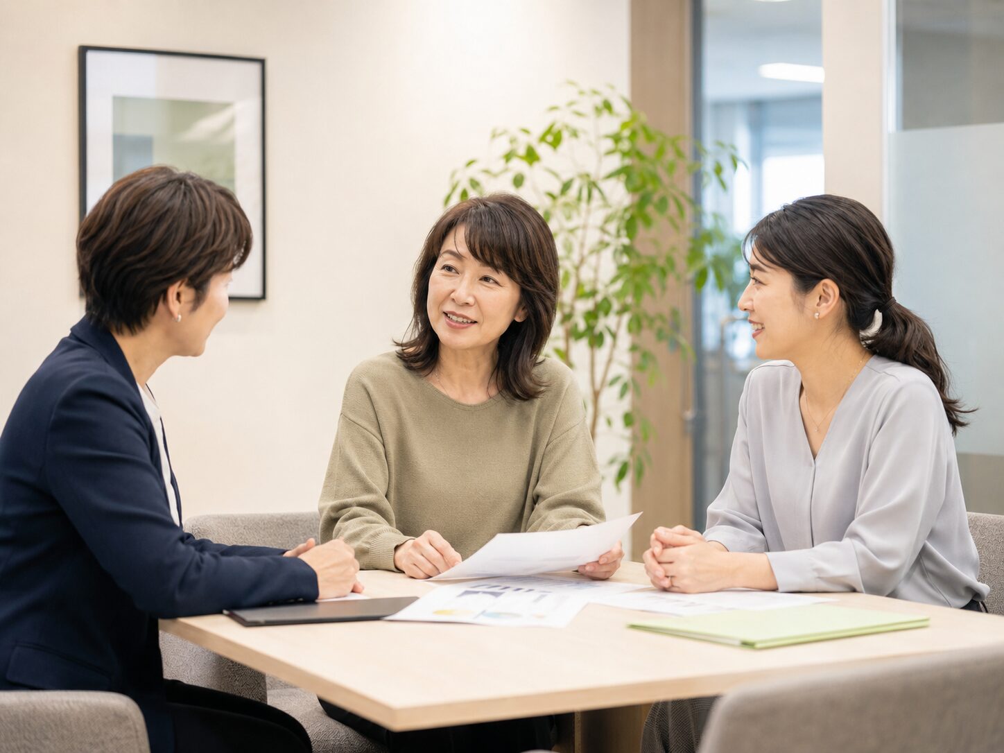 職場で短い打ち合わせをしながら業務分担を確認する場面