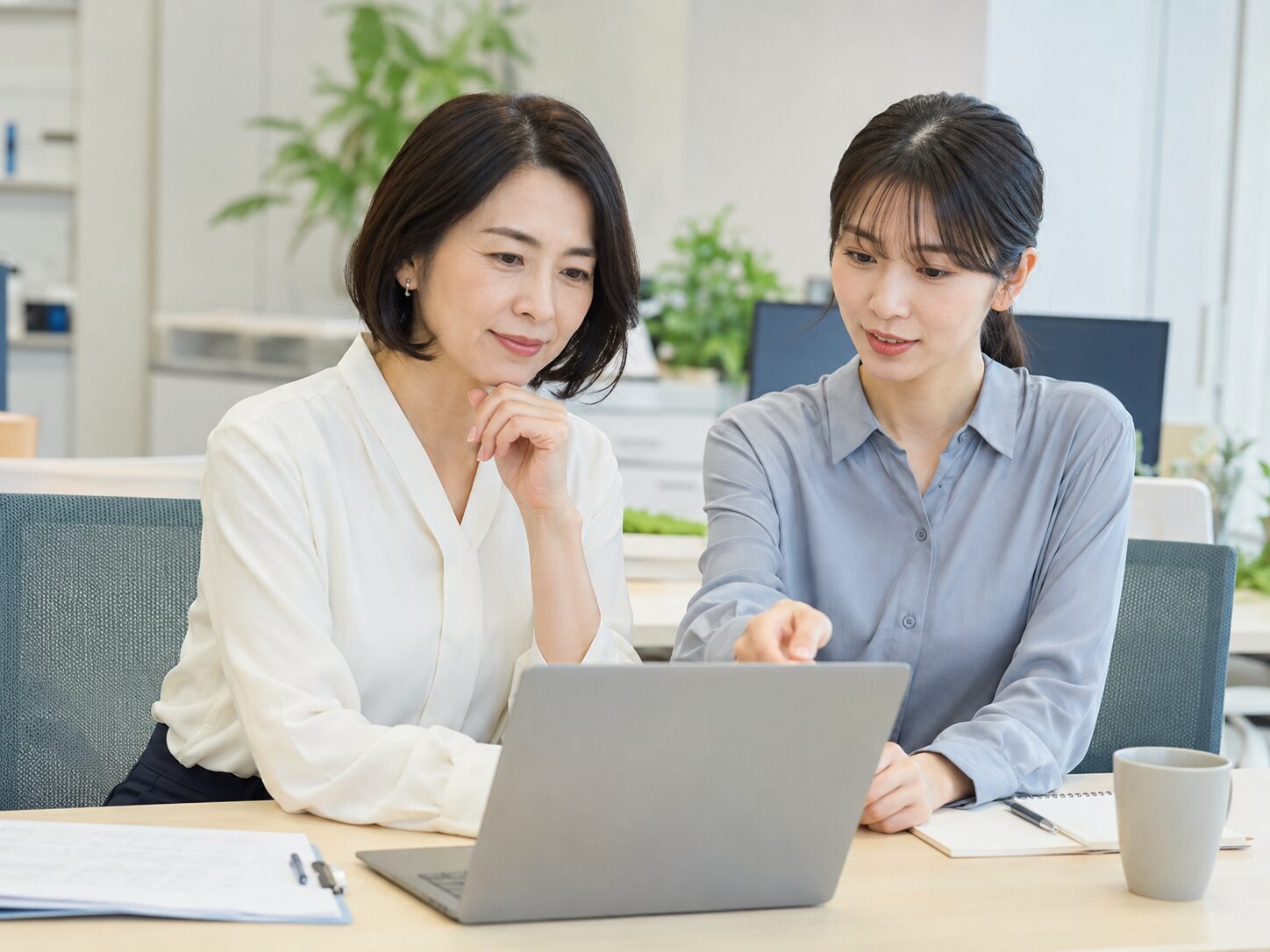 同僚とメール内容を確認しながら仕事の頼み方を整理する場面